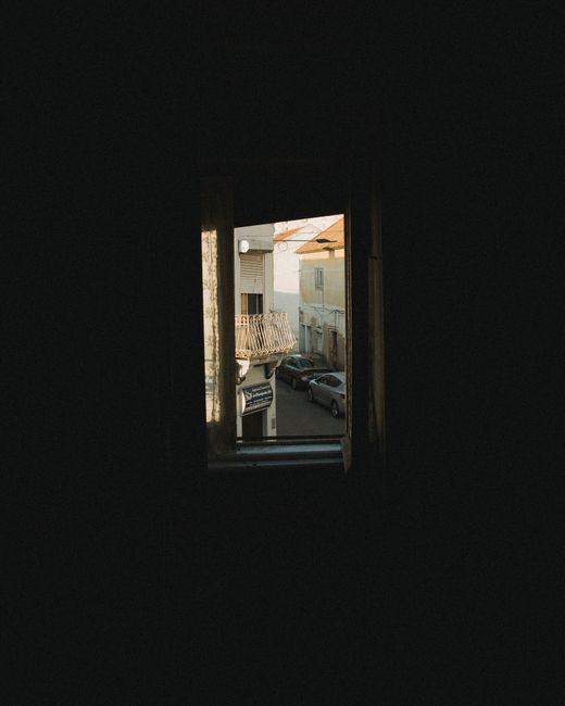 A view of an urban street through a window with cityscape and shadows.