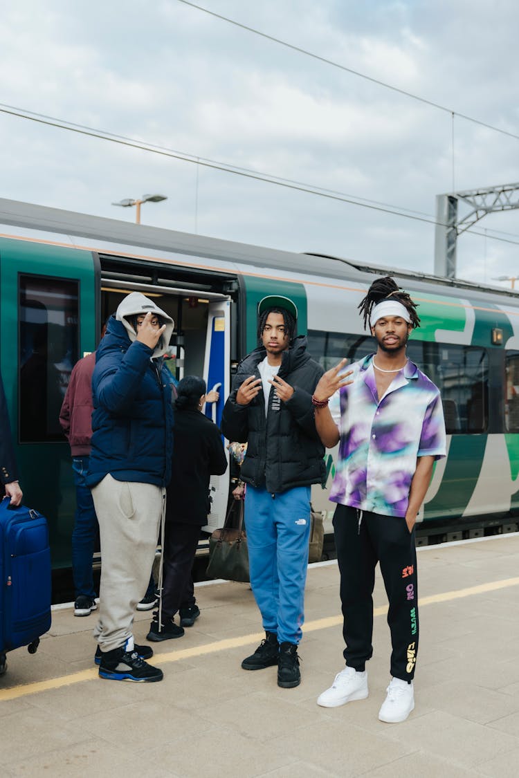 A Group Of Young Men Posing For A Picture At A Train Station Platform 