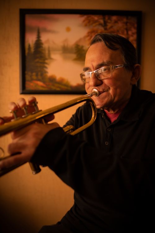 Free Elderly man with eyeglasses playing a trumpet indoors, showcasing passion for music. Stock Photo