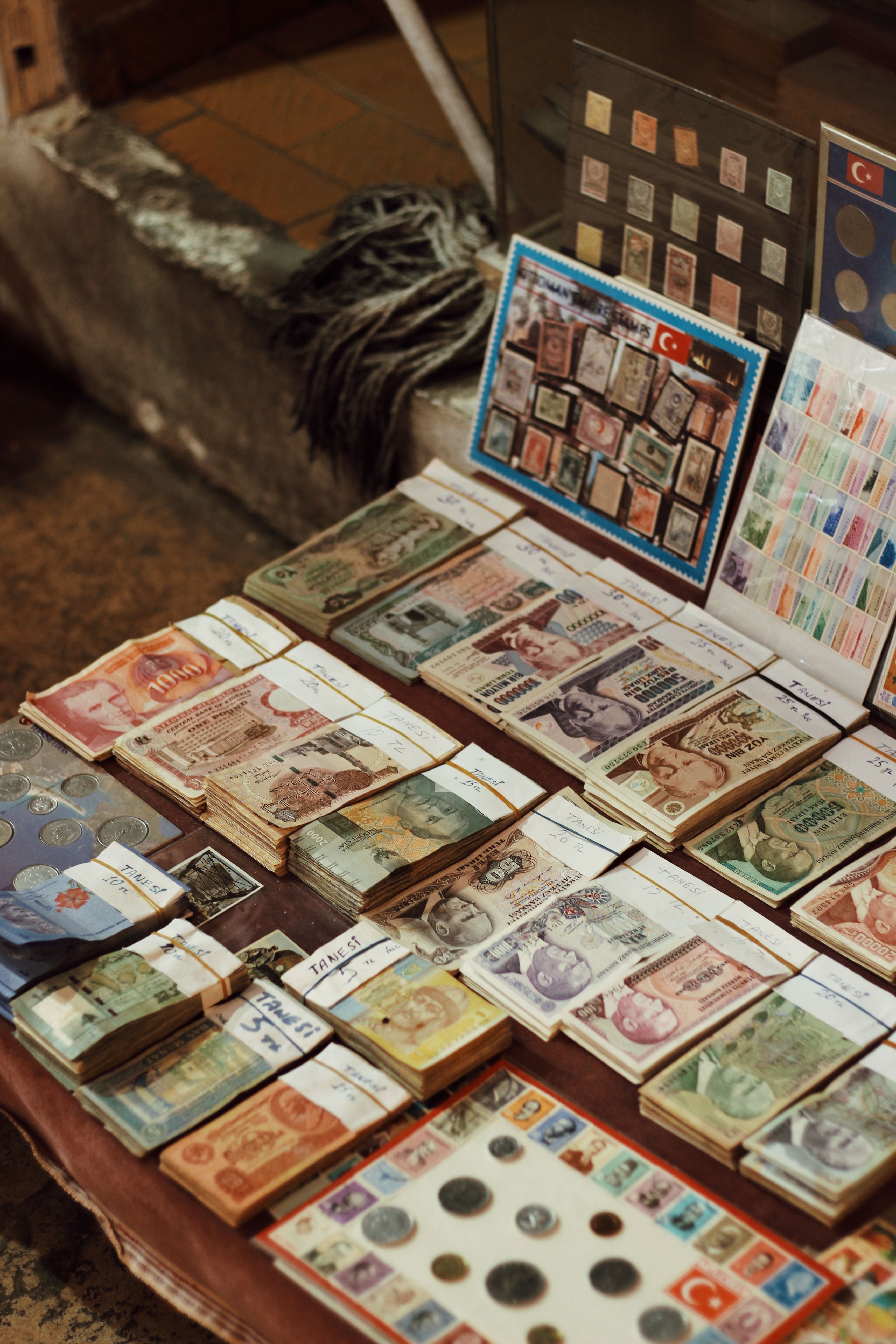 Intriguing close-up of assorted vintage banknotes and coins displayed on a market table.
