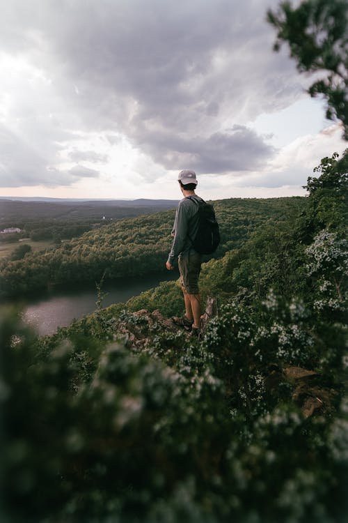 Man Standing on Hill with Forest behind