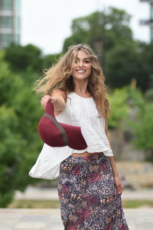 Smiling Blonde Woman Holding Hat