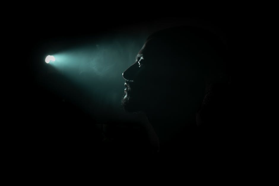 Profile silhouette of a man with dramatic lighting creating a mysterious ambiance.