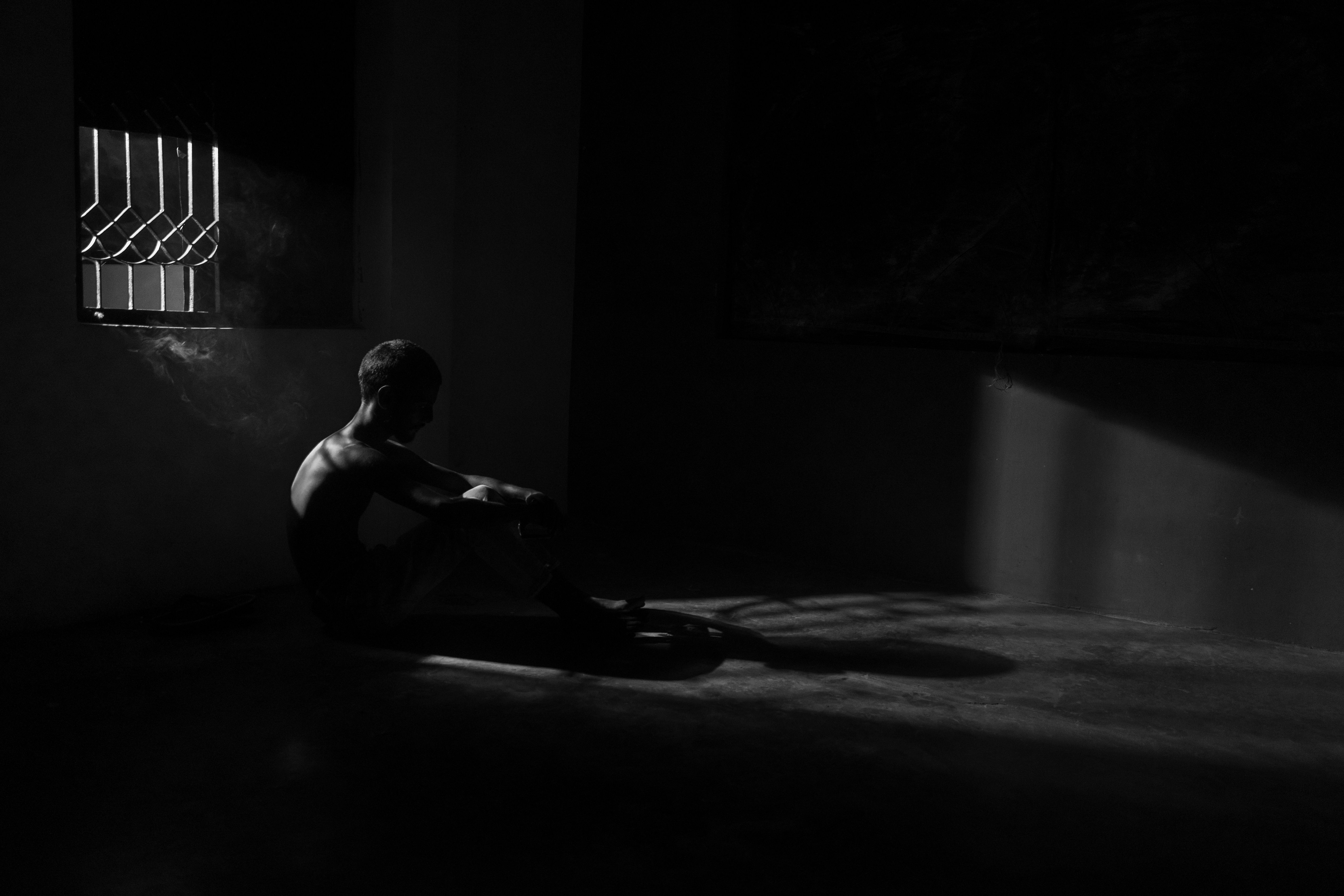 Person sitting alone in dark room