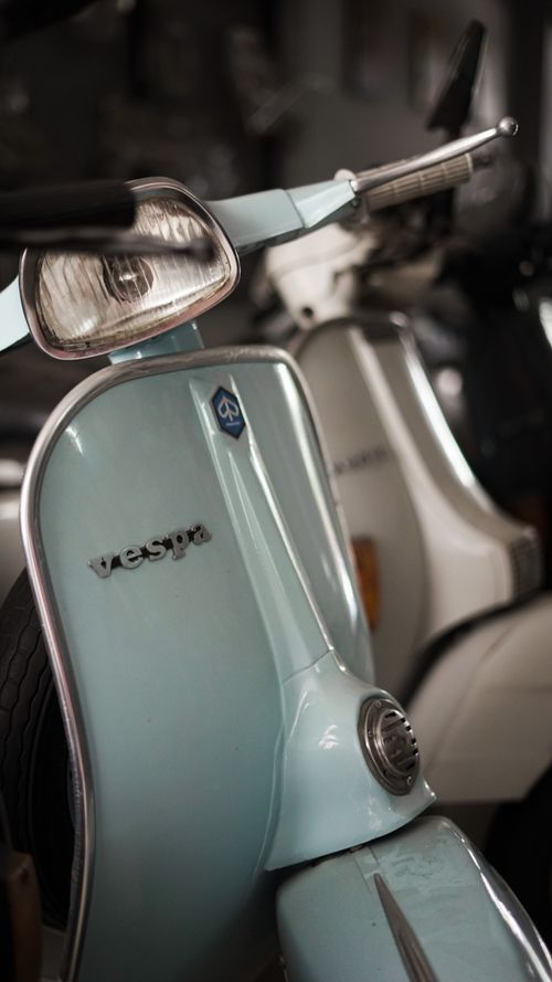 Free Close-up photo of a vintage Vespa scooter in a garage, highlighting its classic design. Stock Photo