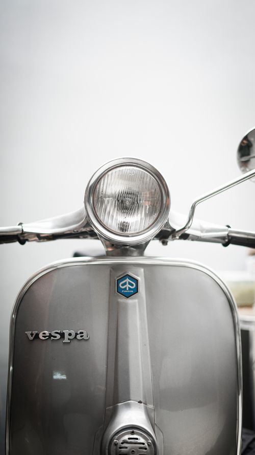 Free Detailed view of a classic Vespa scooter headlight showcasing its iconic design. Stock Photo