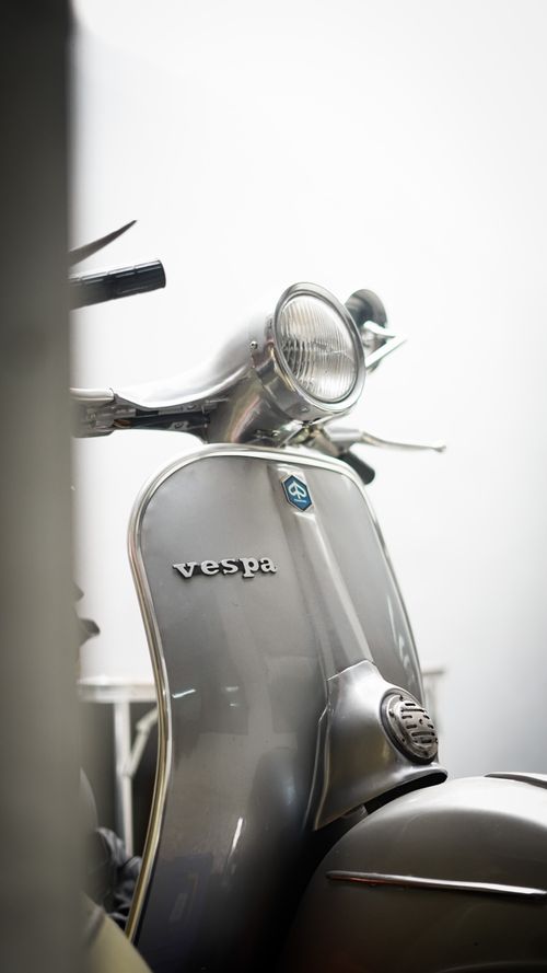 Free A detailed close-up shot of a classic gray Vespa scooter in a vertical composition. Stock Photo