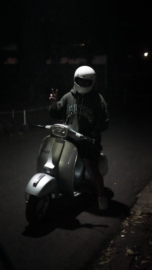 Man on a Motor Scooter Making a Gesture 