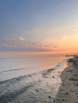 Peaceful beach scene with gentle waves and a colorful sunset sky.