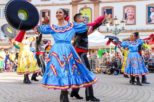 Colorful dancers in traditional Mexican costumes performing at an outdoor festival.