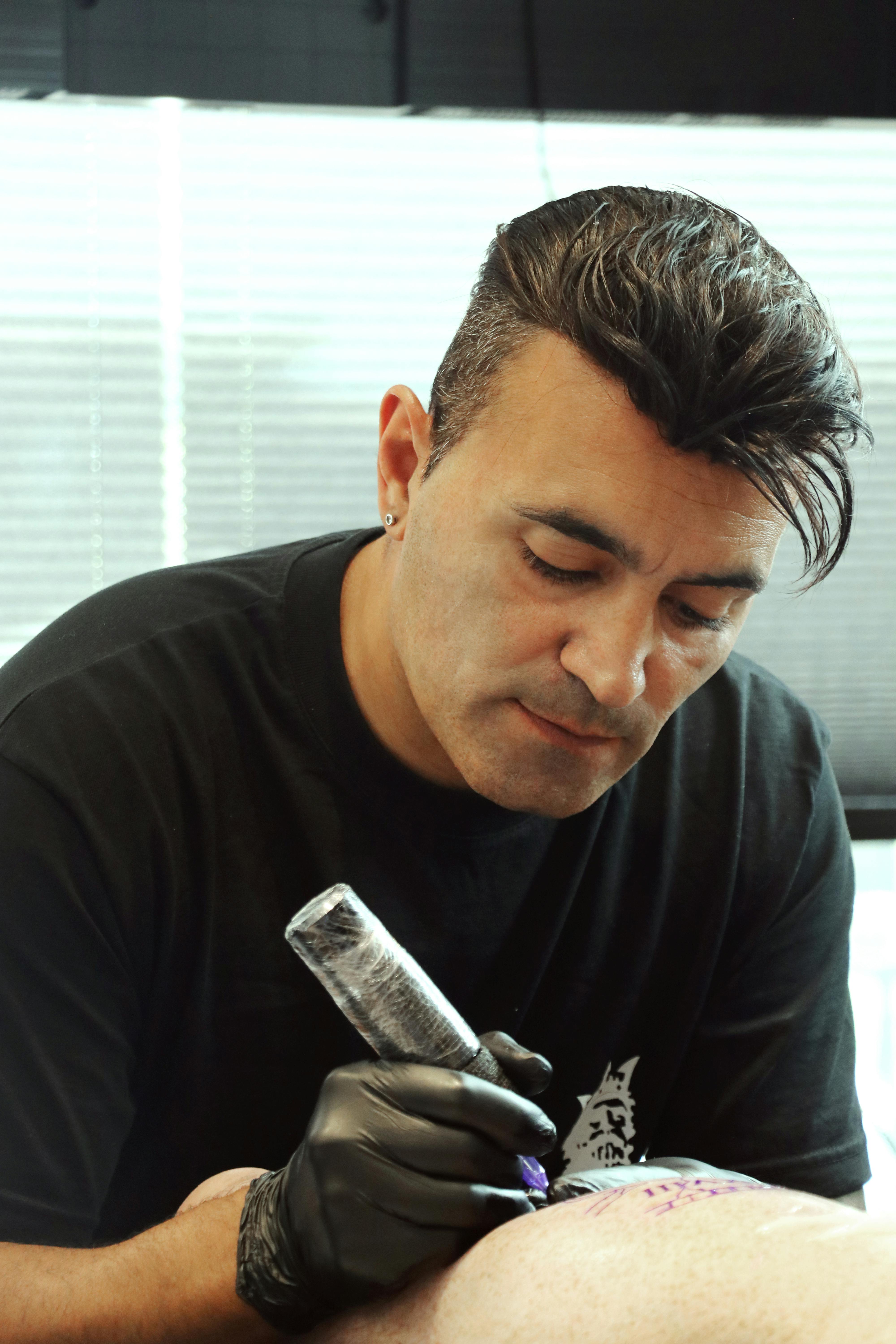 Focused tattoo artist working in Didim, Türkiye studio. Captured with precision.