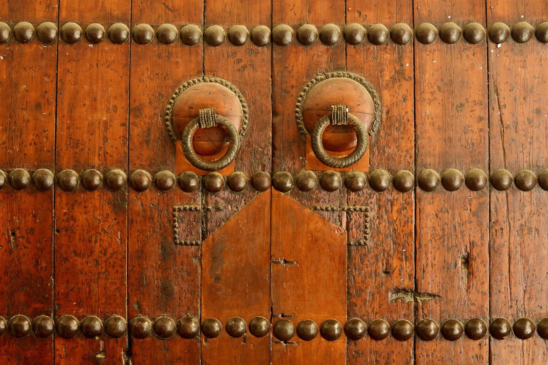 Close-up of a vintage wooden door with brass handles in Fès, Morocco.