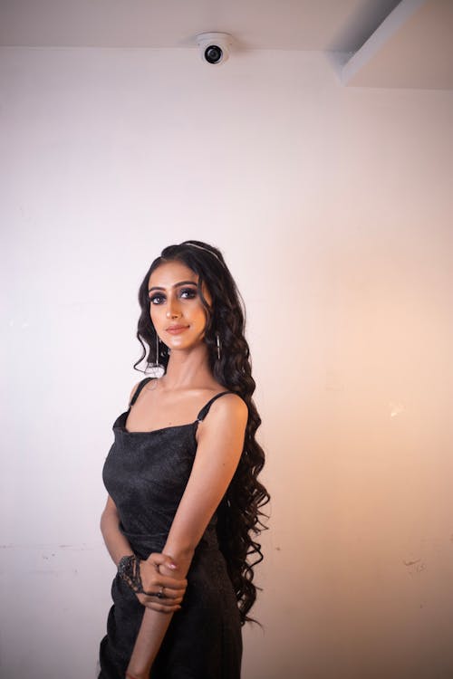 Brunette Woman Posing in Black Slip Dress and Intricate Bracelet