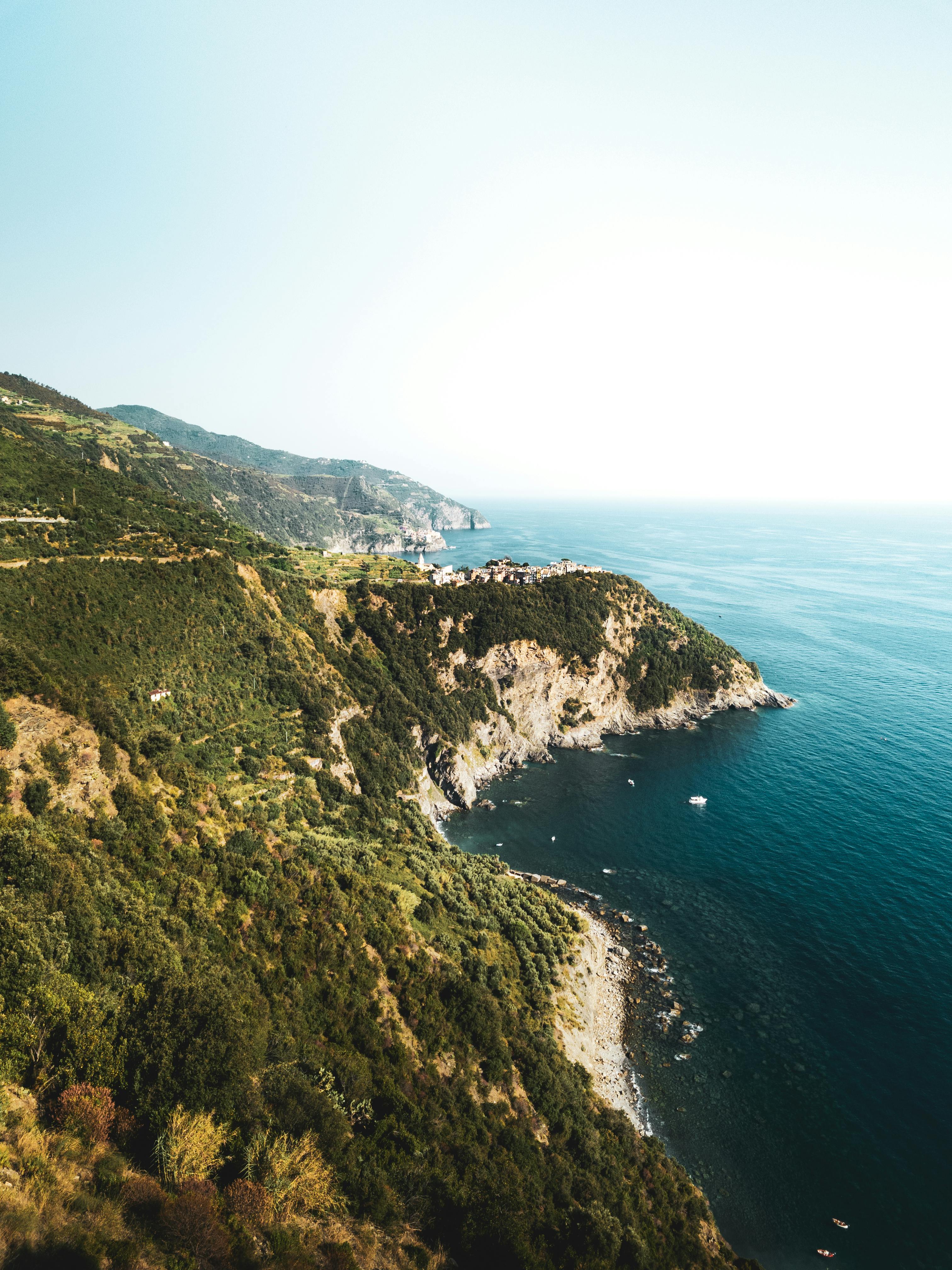 A breathtaking aerial view of the rugged coastline near Vernazza in Liguria, Italy, showcasing lush greenery and pristine waters.