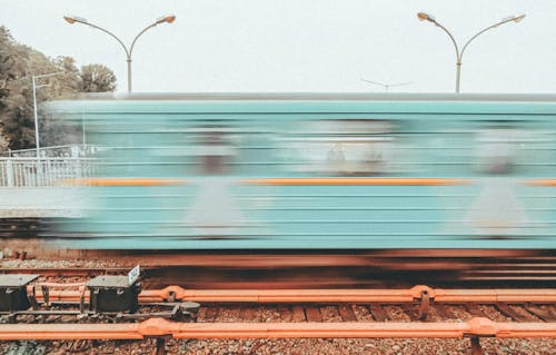 Blurred Motion Photo of a Train Dashing Fast past a Station