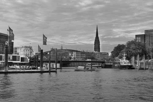 Free Captivating black and white cityscape featuring a bridge and urban architecture over a river. Stock Photo