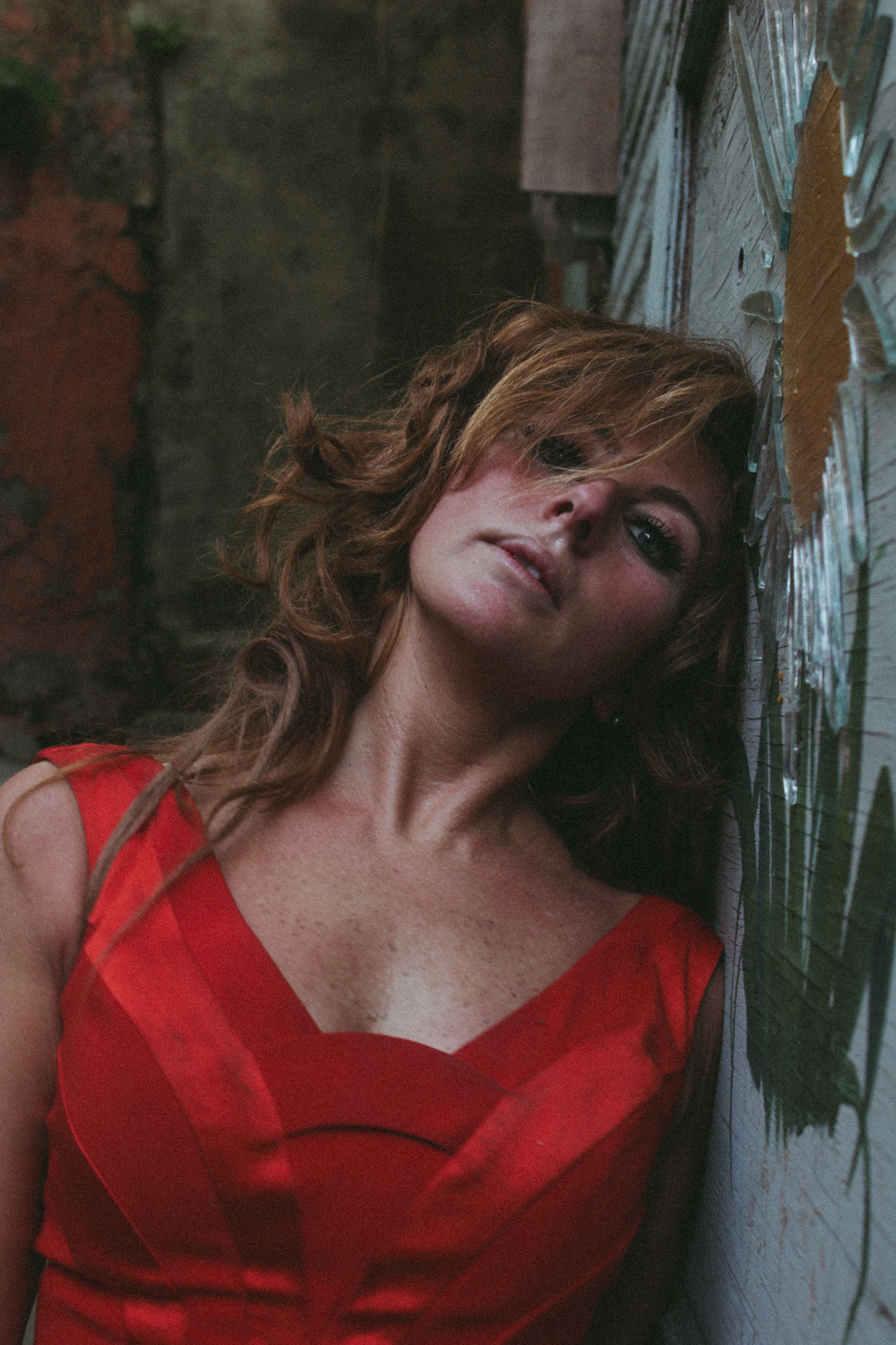 Captivating portrait of a woman in a red dress against an Istanbul wall.