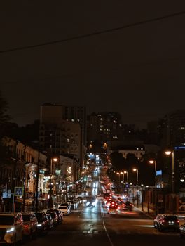 Capture of a bustling night street scene in Vladivostok, Russia, featuring illuminated city lights and urban architecture.