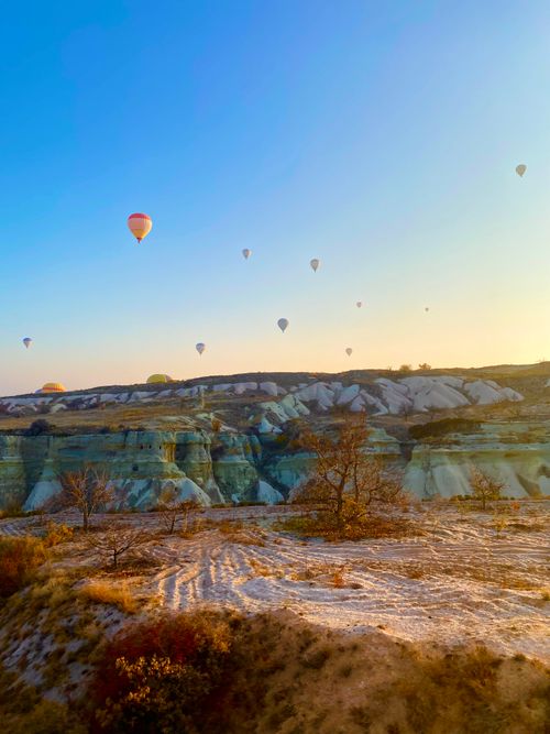 Free Captivating view of hot air balloons floating over the iconic rocky landscapes of Cappadocia, Türkiye. Stock Photo