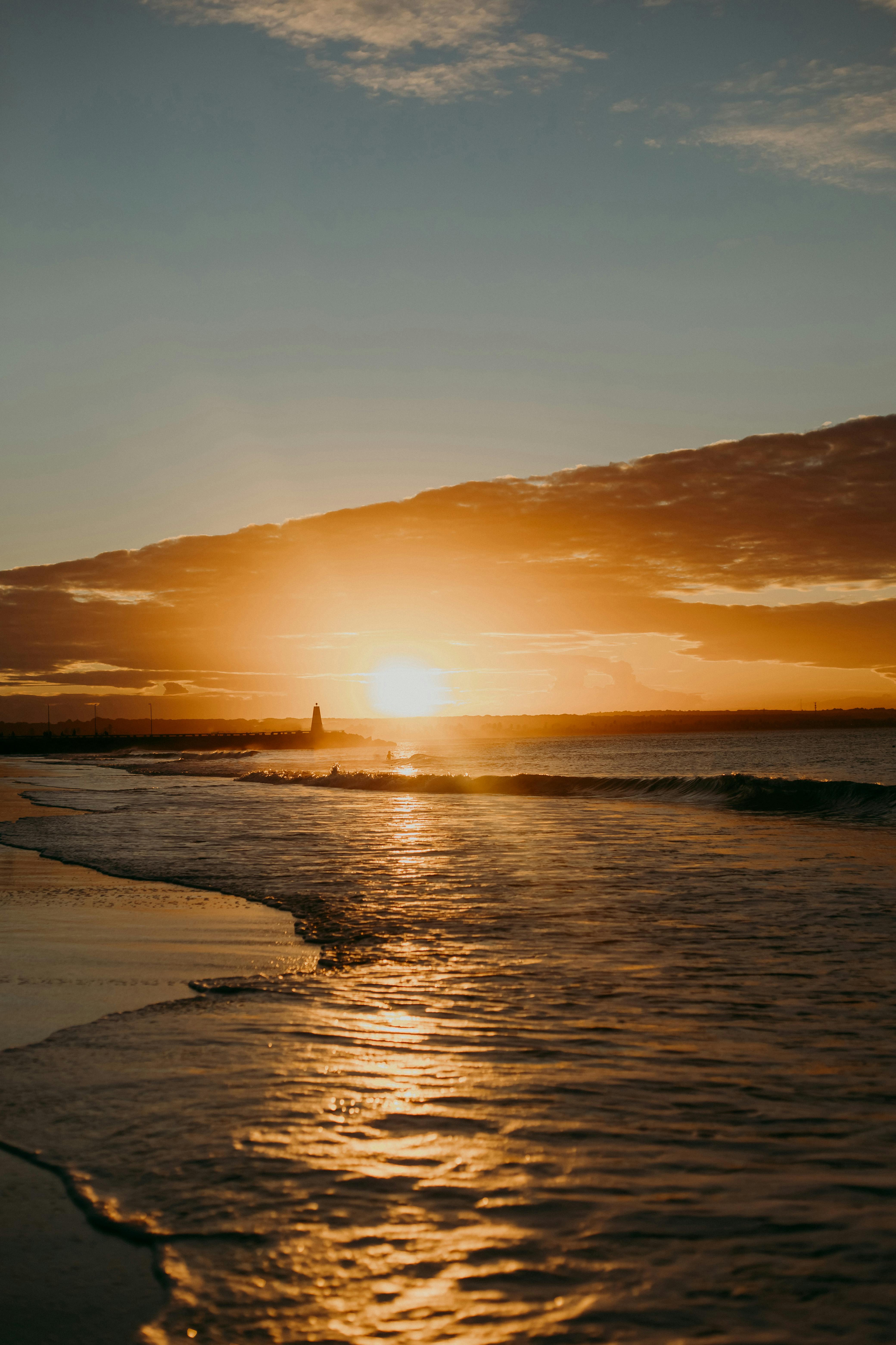 Gorgeous sunset over João Pessoa beach with golden hues reflecting on ocean waves.