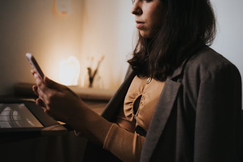 Woman in Suit Jacket Sitting with Smartphone