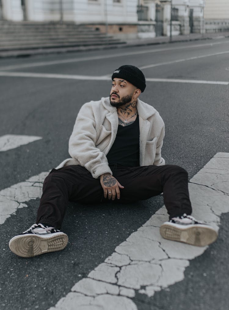 Stylish Man In Hat Sitting On Crossing On Road