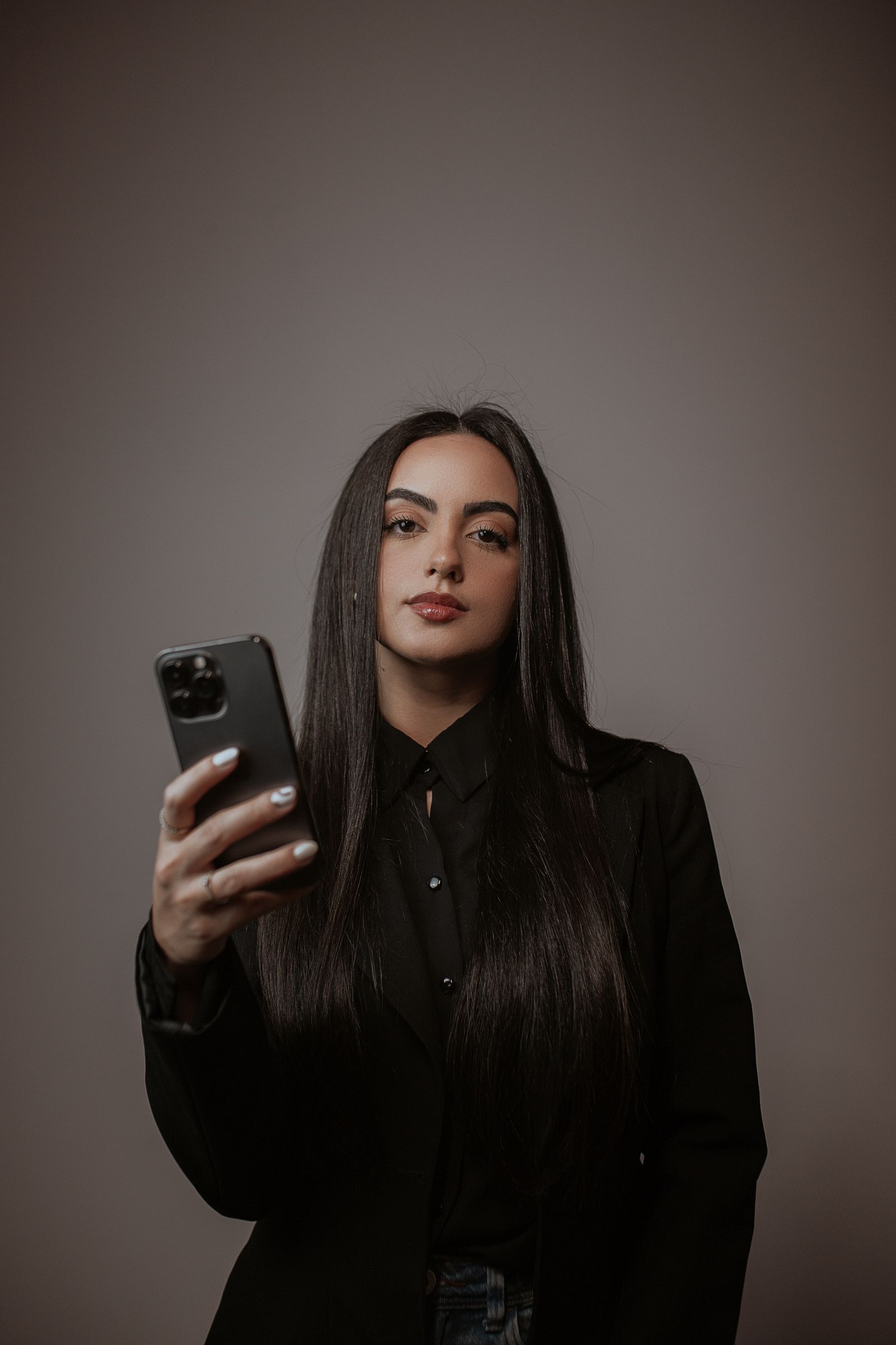 Woman with long straight dark hair wearing a black blazer