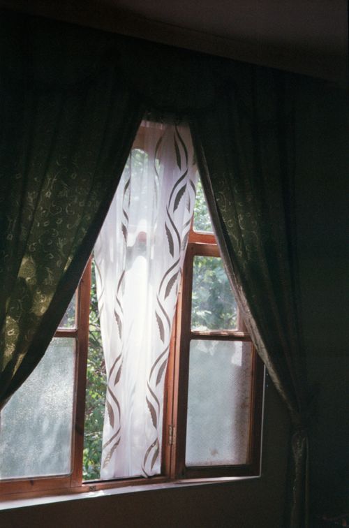 Free A warm and inviting room with elegant curtains framing a sunlit window. Stock Photo