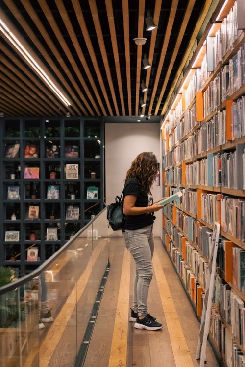 Free A woman browsing books in a stylish bookstore in Ciudad de México, showcasing contemporary interior design. Stock Photo