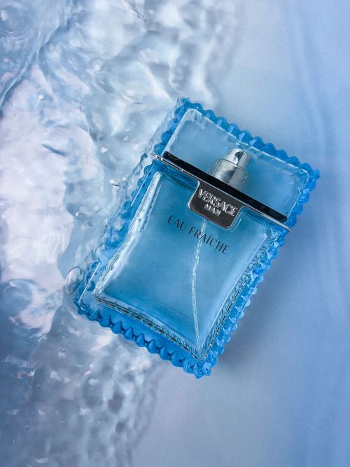Free Stylish blue perfume bottle on water-like surface, captured in detail. Stock Photo