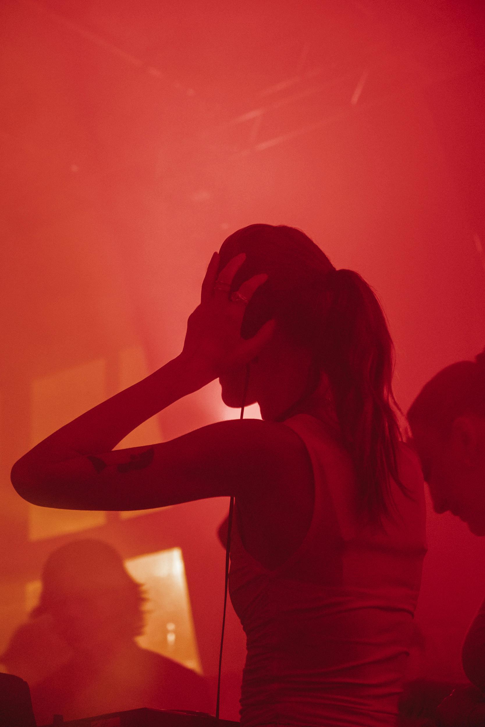 female dj wearing headphones at the club