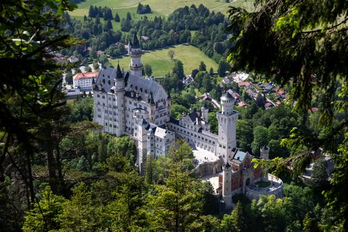 Free Aerial view of Neuschwanstein Castle in Bavaria, surrounded by lush greenery. Stock Photo