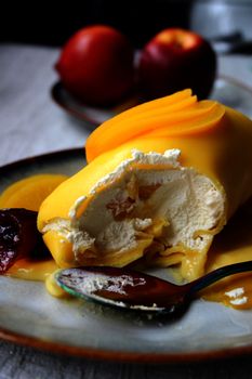 A close-up of a tasty mango-flavored dessert with fresh fruit and cream, perfect for food lovers.