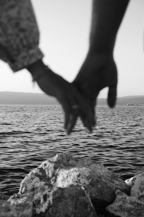Couple Holding Hands on a Coast in Black and White
