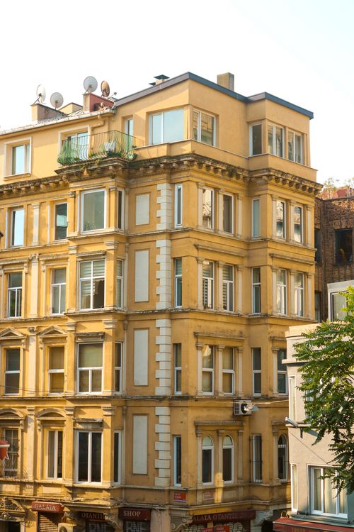 Free Yellow historic apartment building facade in İstanbul's urban district, showcasing architectural details. Stock Photo
