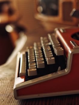 Close-up of a retro orange typewriter with muted lighting, offering a nostalgic feel.