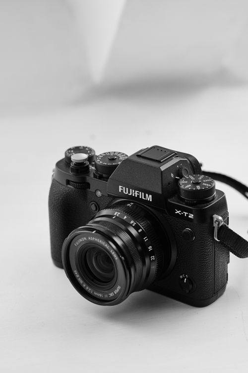Free Black Fujifilm X-T2 camera in detail against a neutral backdrop. Stock Photo