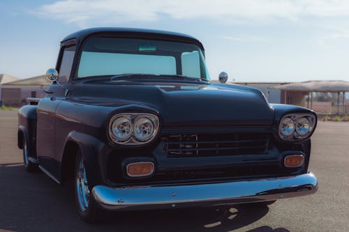 A Black Vintage Pick-up Truck on a Parking Lot 