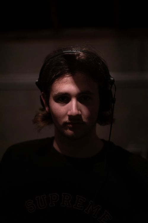Free Dark and atmospheric portrait of a young man wearing headphones indoors. Stock Photo