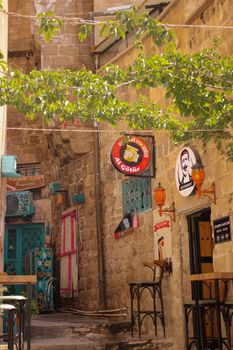 Charming cobblestone alley with vibrant cafes and hanging signs, ideal for urban exploration enthusiasts.