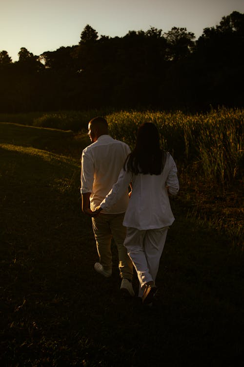 Couple Holding Hands and Walking in the Countryside at Dusk 