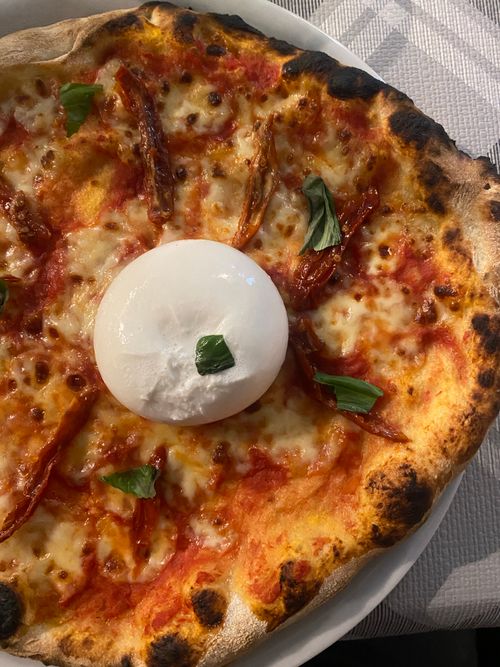 Free Mouth-watering Neapolitan pizza topped with creamy burrata and fresh basil. Stock Photo