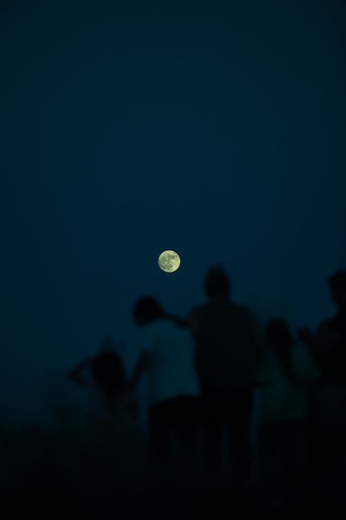 Free Silhouette of People against Night Sky with Full Moon Stock Photo