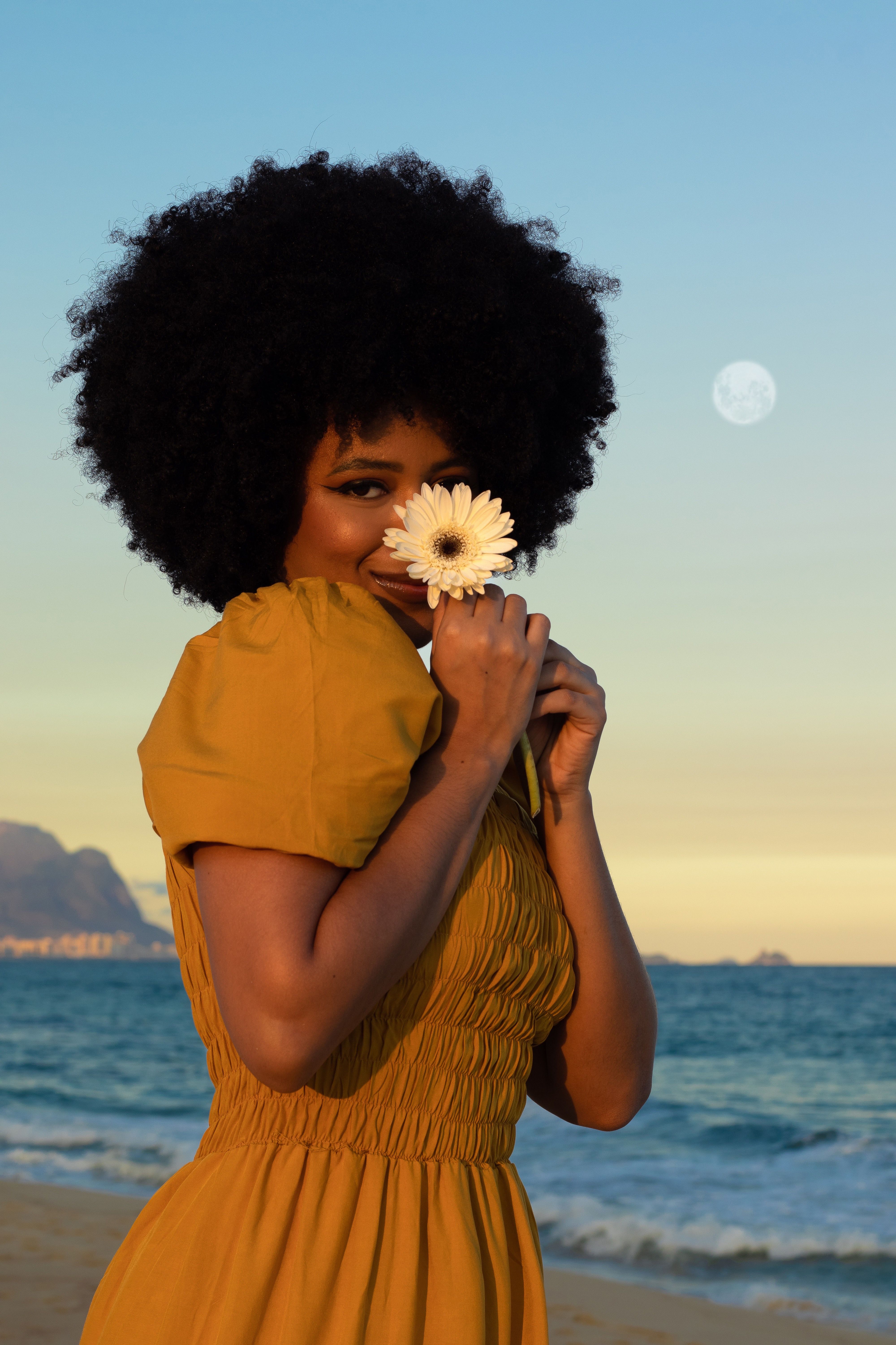 Young Woman in a Yellow Dress Holding a Flower on a Beach at Sunset ...