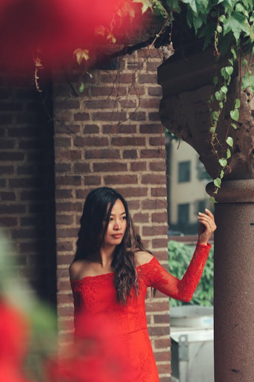 Young Woman in a Red Dress Posing Outside 
