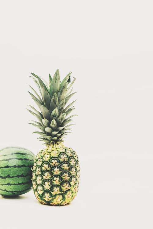 Photo of Green Pineapple and Watermelon Fruits Against White Background