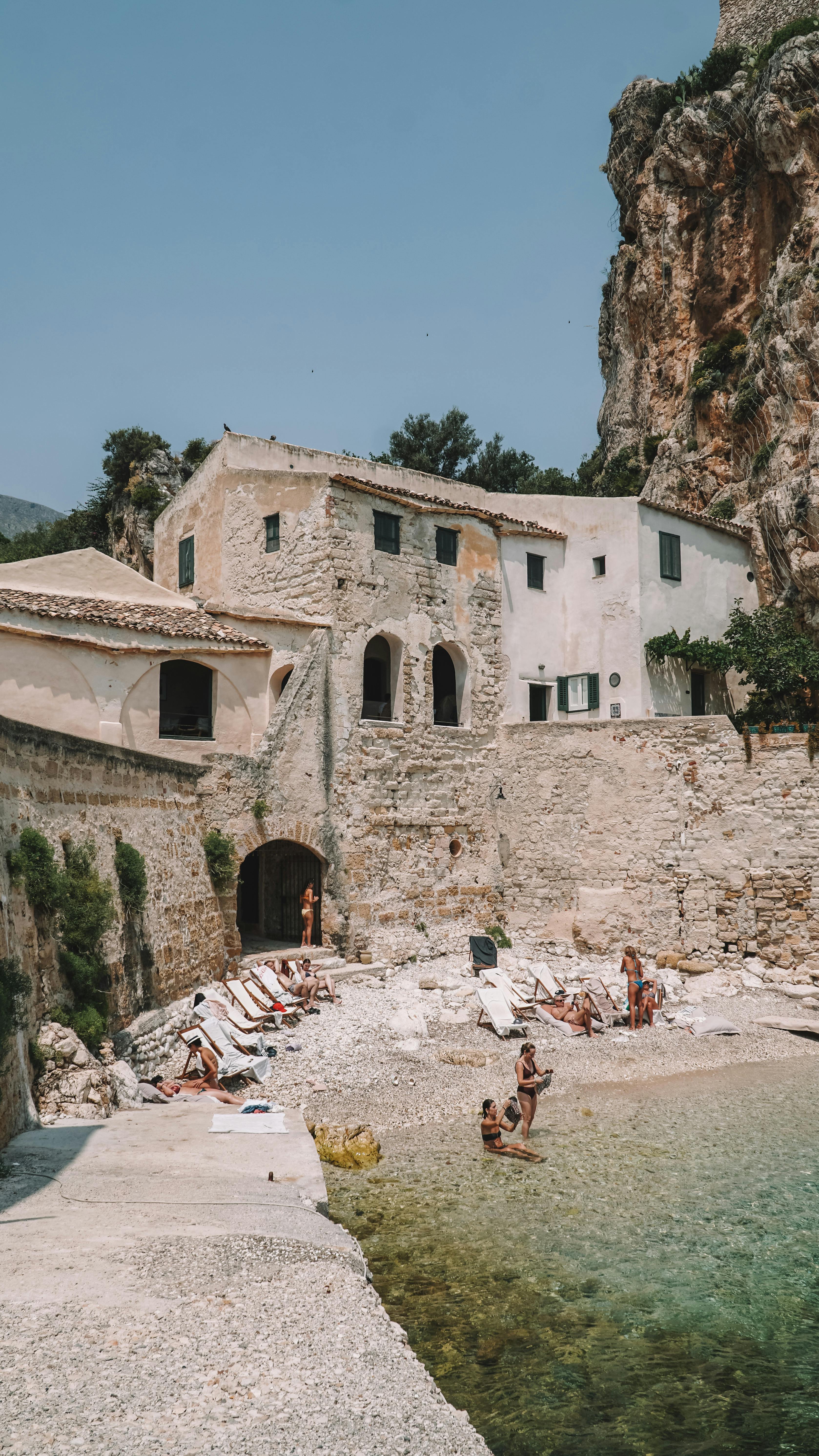 Rustic beachside buildings in Scopello, Sicily, under the summer sun.