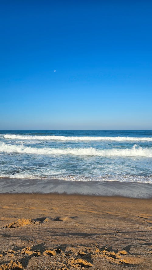 Waves Washing Up the Shore under Clear Blue Sky 