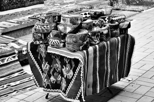 Monochrome image showcasing a selection of traditional handmade hats on a decorated table.