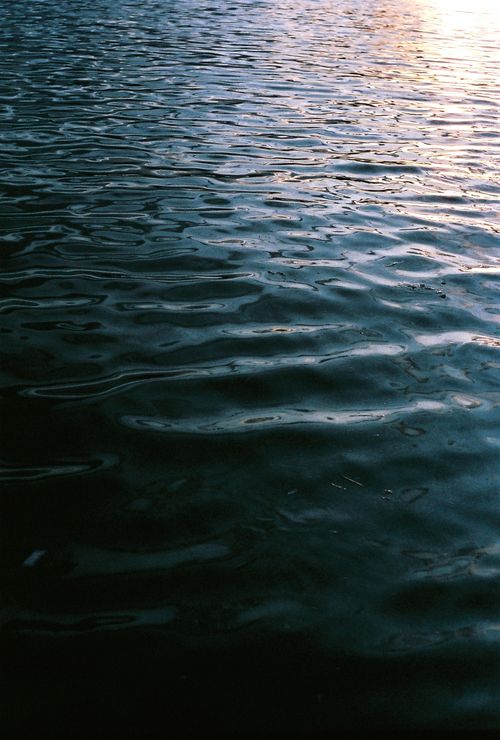 Free Calm waters reflecting the sky at sunset with gentle ripples creating a soothing effect. Stock Photo